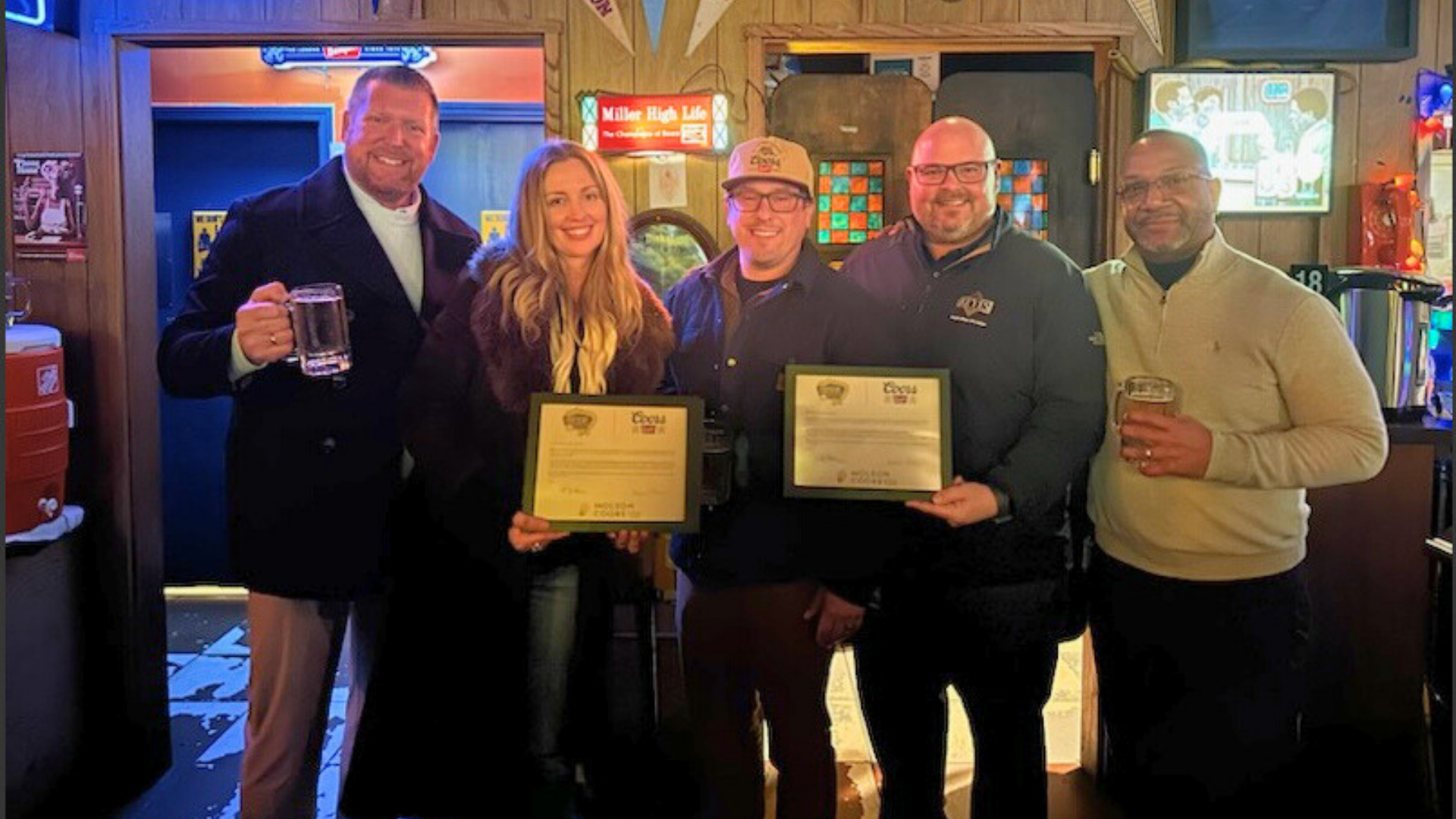 Group of people smiling holding an award