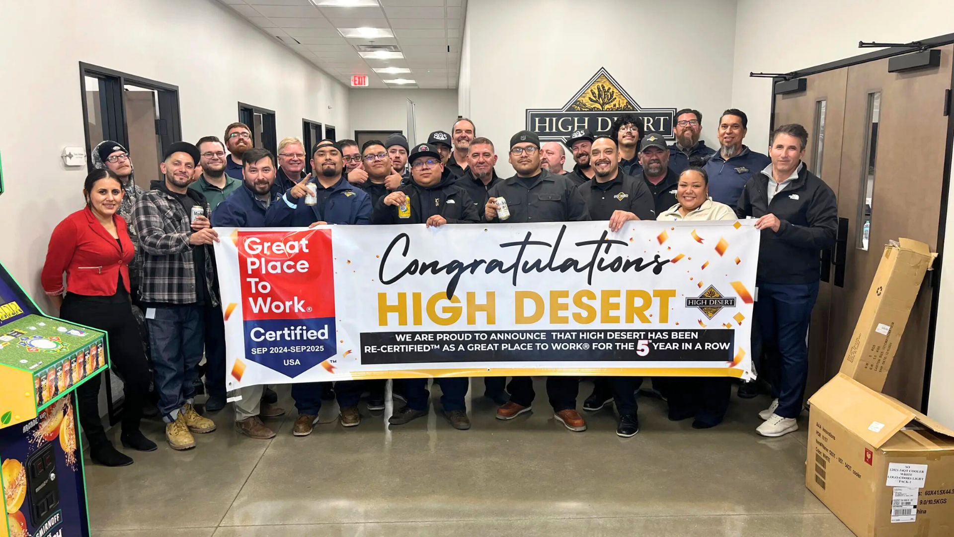 Group of people smiling while holding workplace award sign