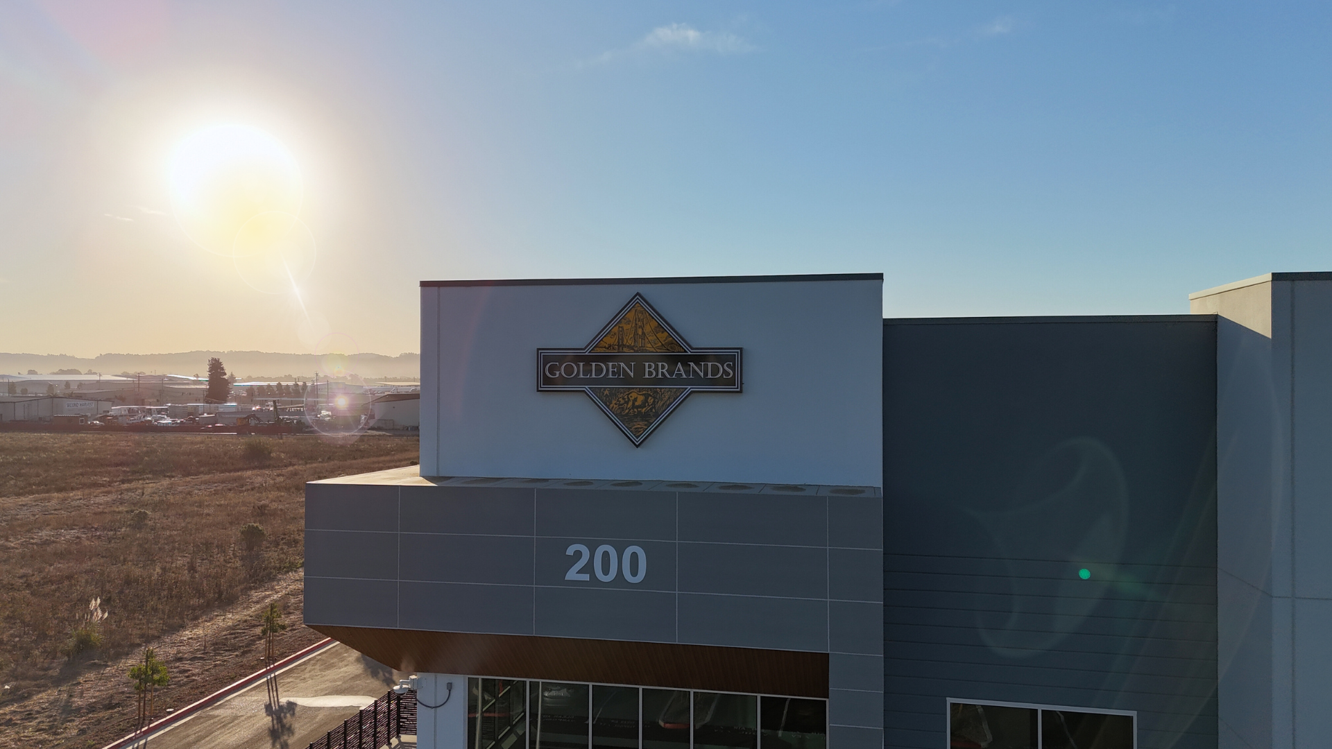 Sunset over a large warehouse with a Golden Brands logo on the building