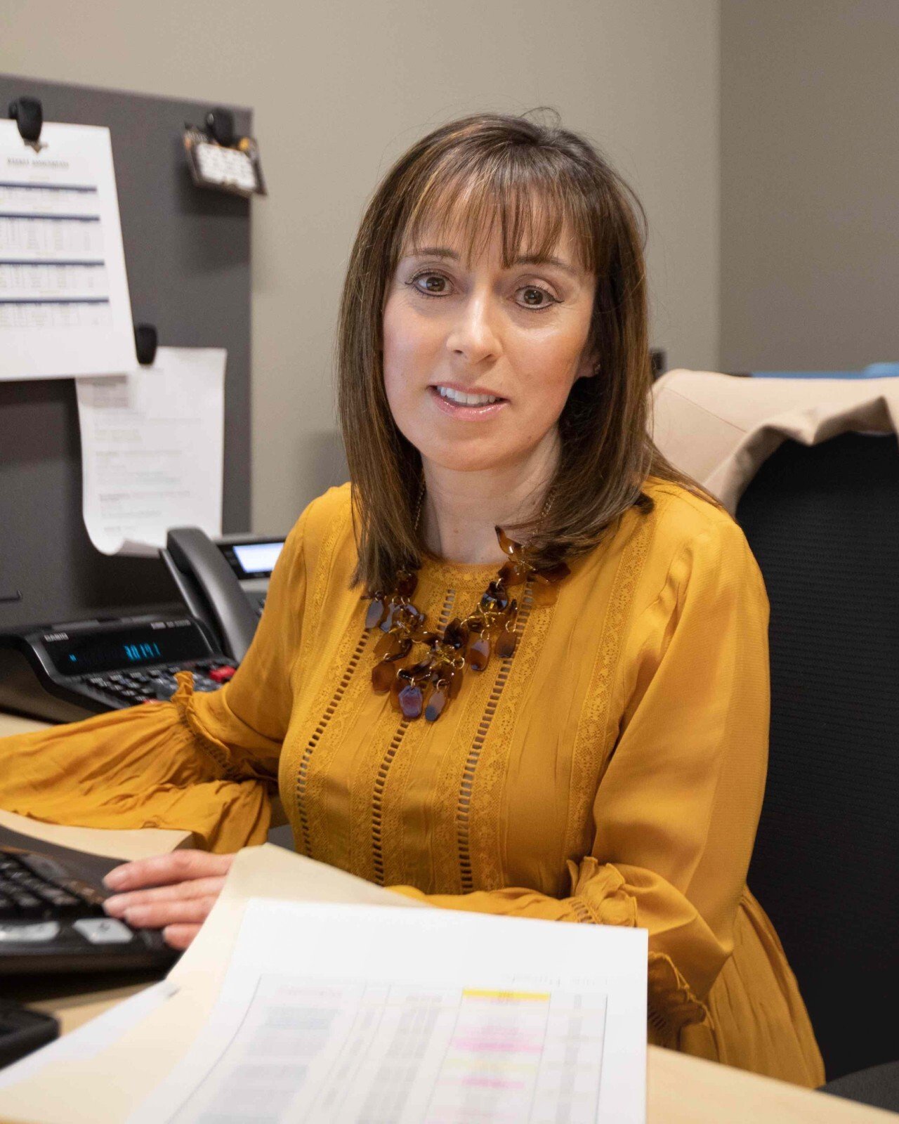 A woman in a yellow short working in the office