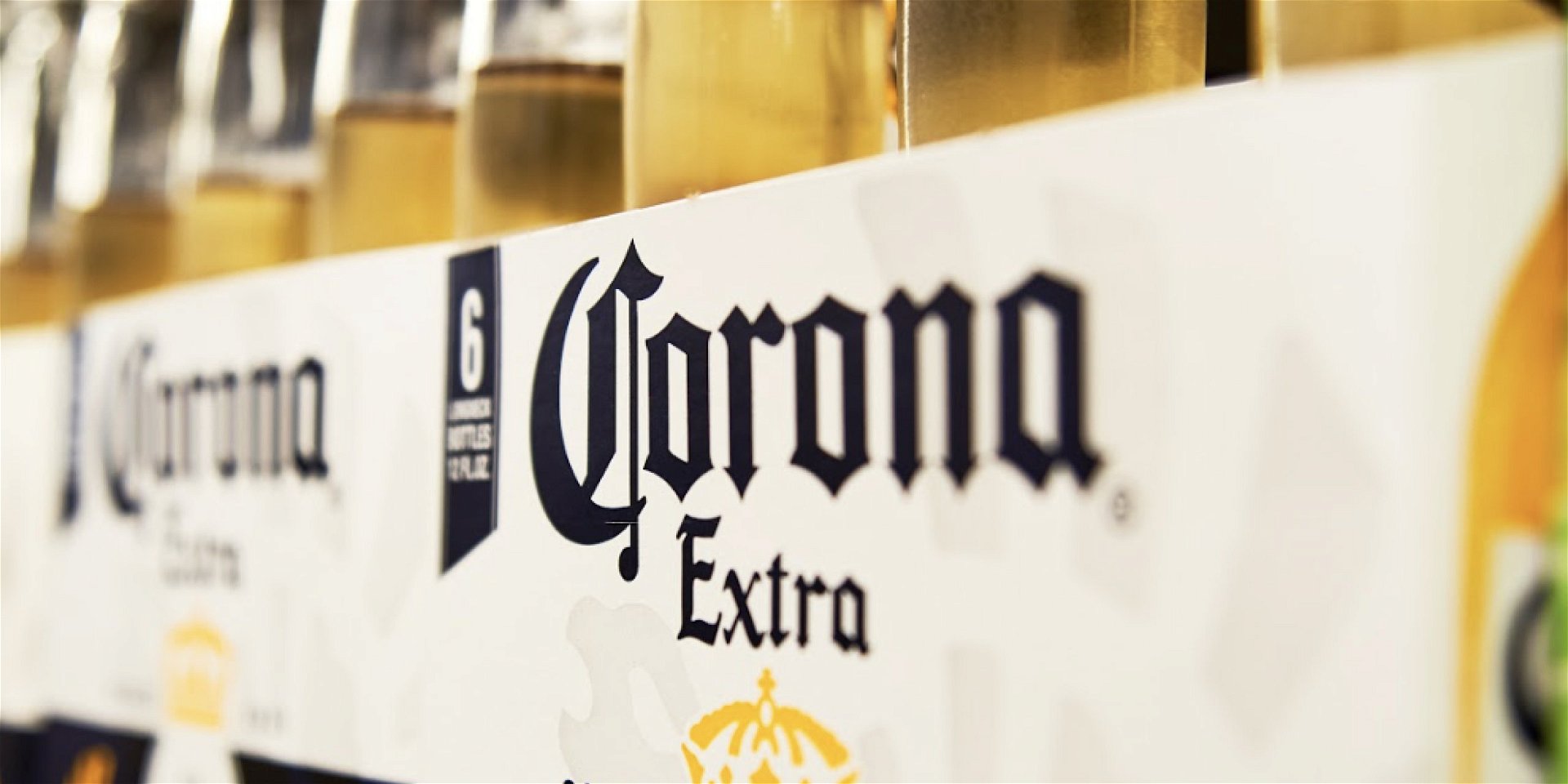 A close up of a Corona Extra case in a cooler space of a grocery store